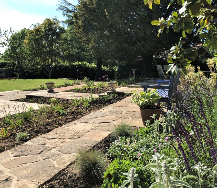 Natural stone pathways and borders for a sloping garden, designed by ...